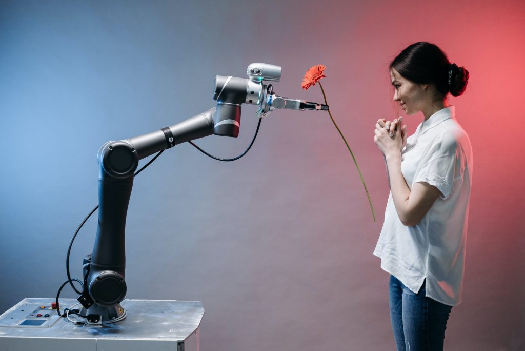Junge Frau bekommt Blume von Roboter überreicht